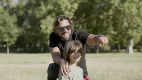 Father-with-disability-sitting-with-son-on-lawn-in-park